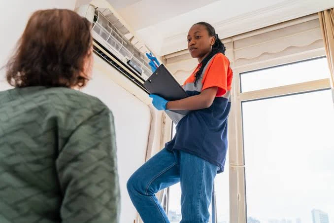 Technician explaining an indoor air conditioning inspection to a homeowner