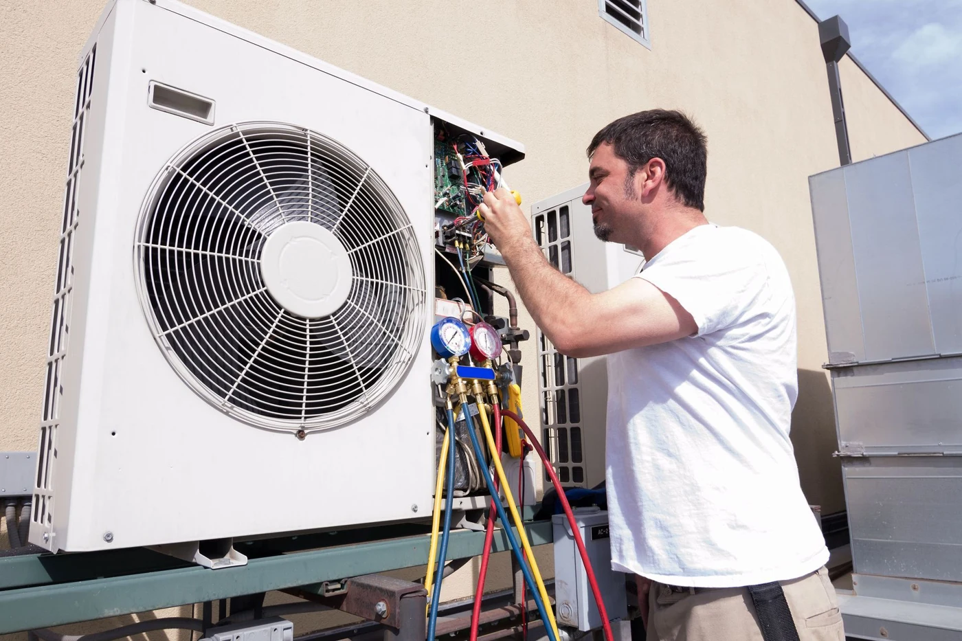 HVAC technician inspecting an outdoor air conditioning system